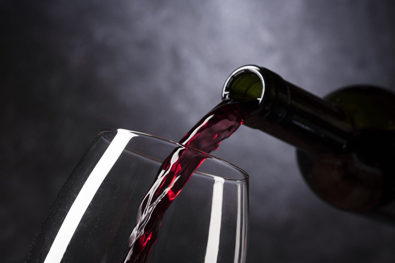 Imagen de vino tinto vertido en una copa de vino